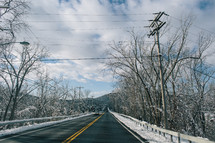 power lines over a road and snow 