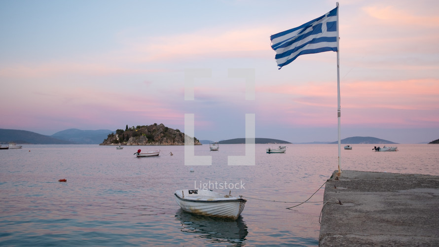 boat tied to a shore and Greek Flag 