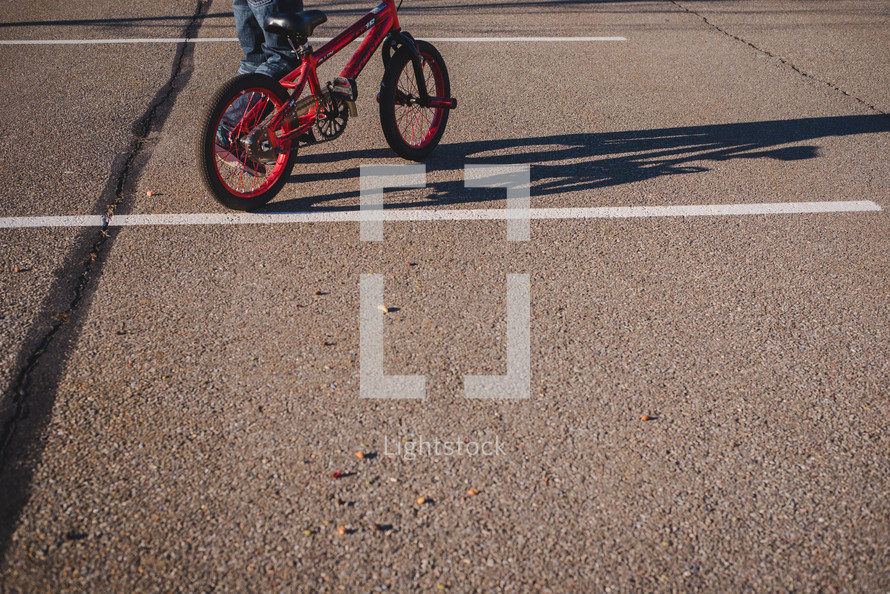 boy riding a bike in a parking lot 