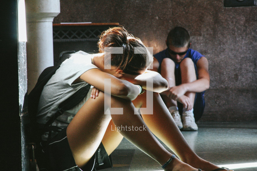 woman and man, sitting on the floor, praying or thinking