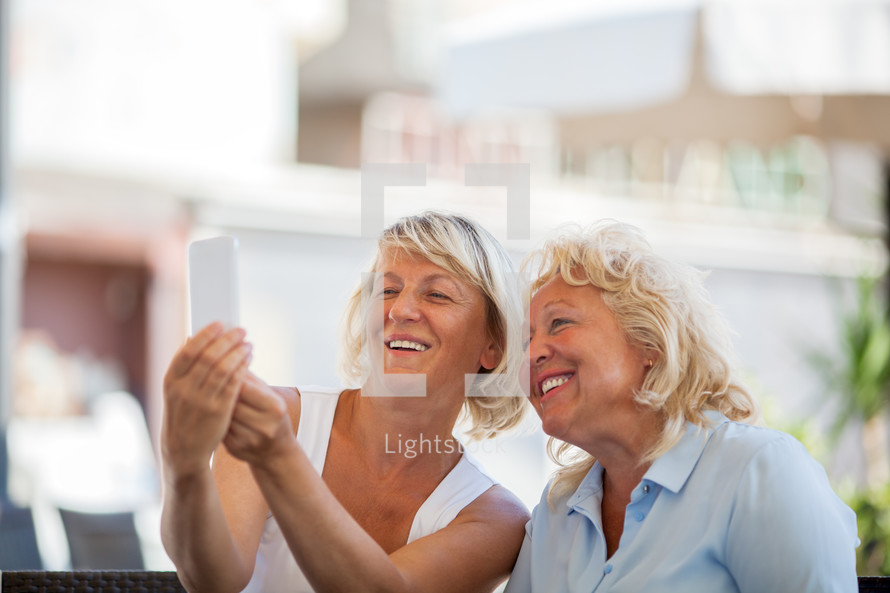 Happy senior women making mobile selfie