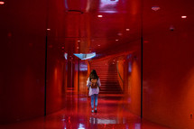 a woman walking down a hallway 