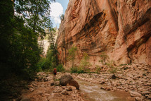 a woman backpacking along a stream bed