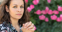 a woman praying in a garden 