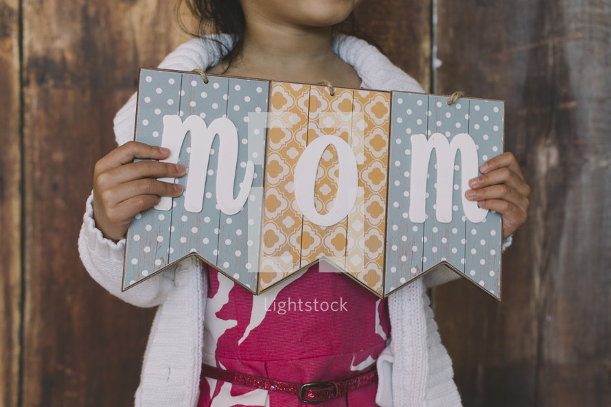 girl child holding a mom sign 