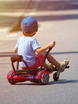 boy on hoverboard or gyroscooter with kart accessory kit outdoor.