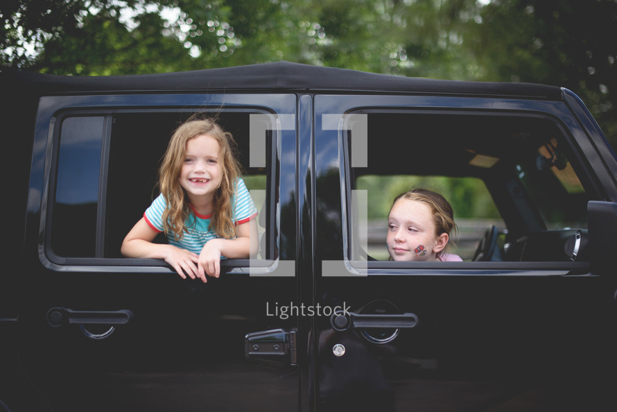 sisters looking out of Jeep windows 