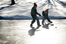 kids playing hockey on a frozen lake 