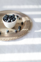 blueberries in a cup on a silver tray 