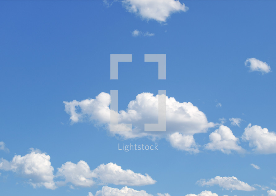 Fluffy white clouds in a blue sky - background