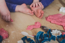 a child plays with playdough and cutter shapes