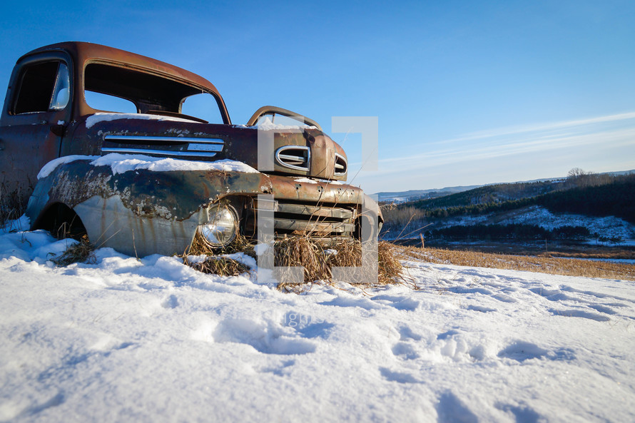 rusted abandoned vehicle in snow 