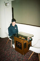 a man sitting at an arcade table 