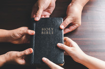 People holding a Bible