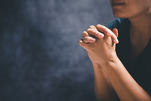 Person's hands clasped in prayer