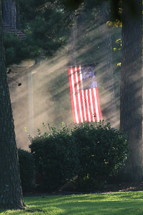 American flag on a flag pole in a backyard 