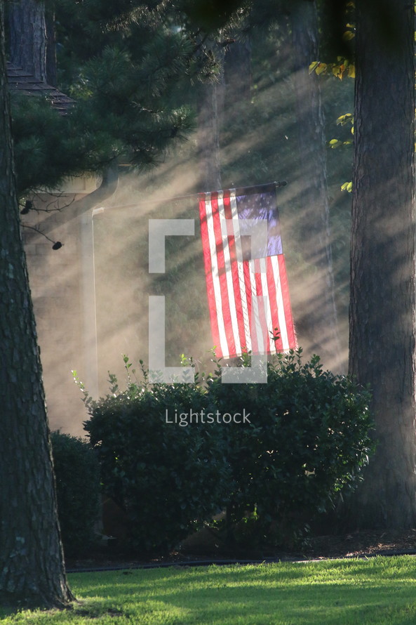 American flag on a flag pole in a backyard 