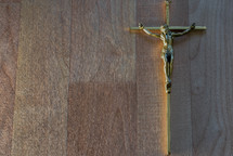 gold crucifix on a wood background 