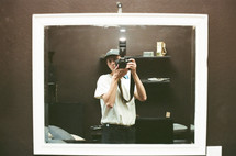 a man holding a camera in a mirror 