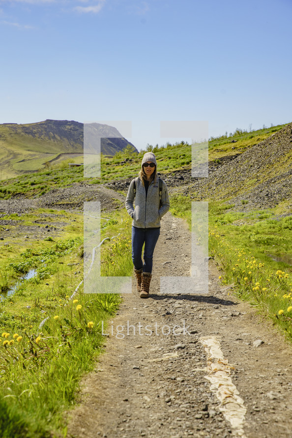a woman walking on a dirt path in Iceland 