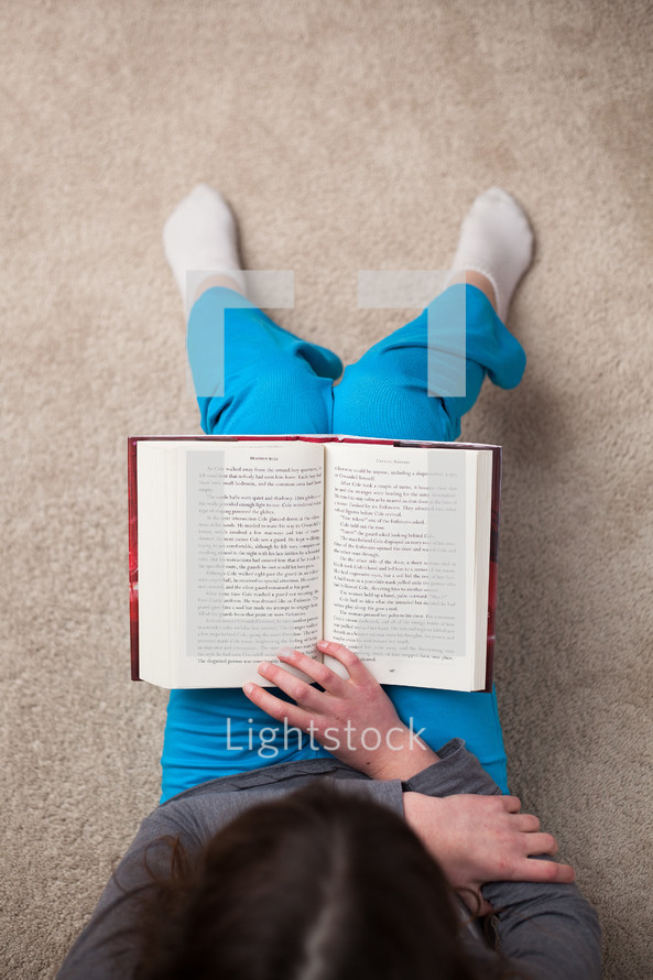 girl sitting reading a Bible 