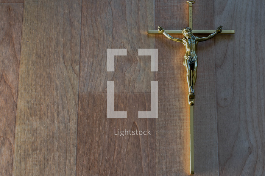 gold crucifix on a wood background 