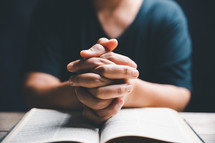 Woman praying on a Bible