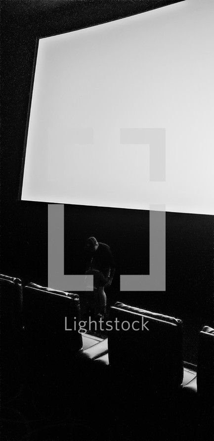 man in a dark auditorium 