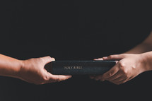 People holding a Bible