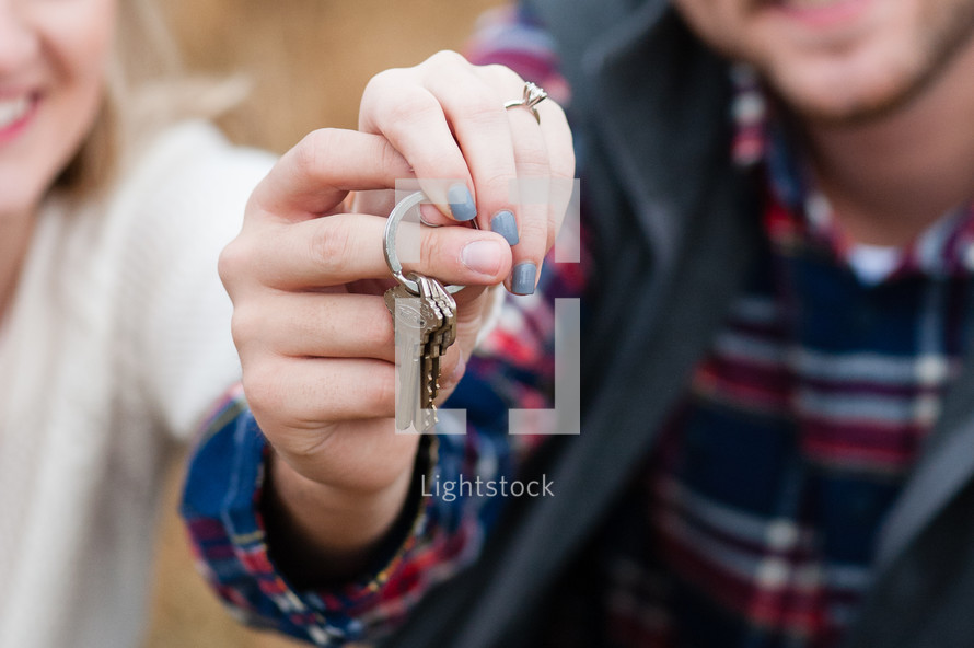 a couple holding keys to a new house 
