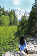 woman looking out at a snow capped mountain peak