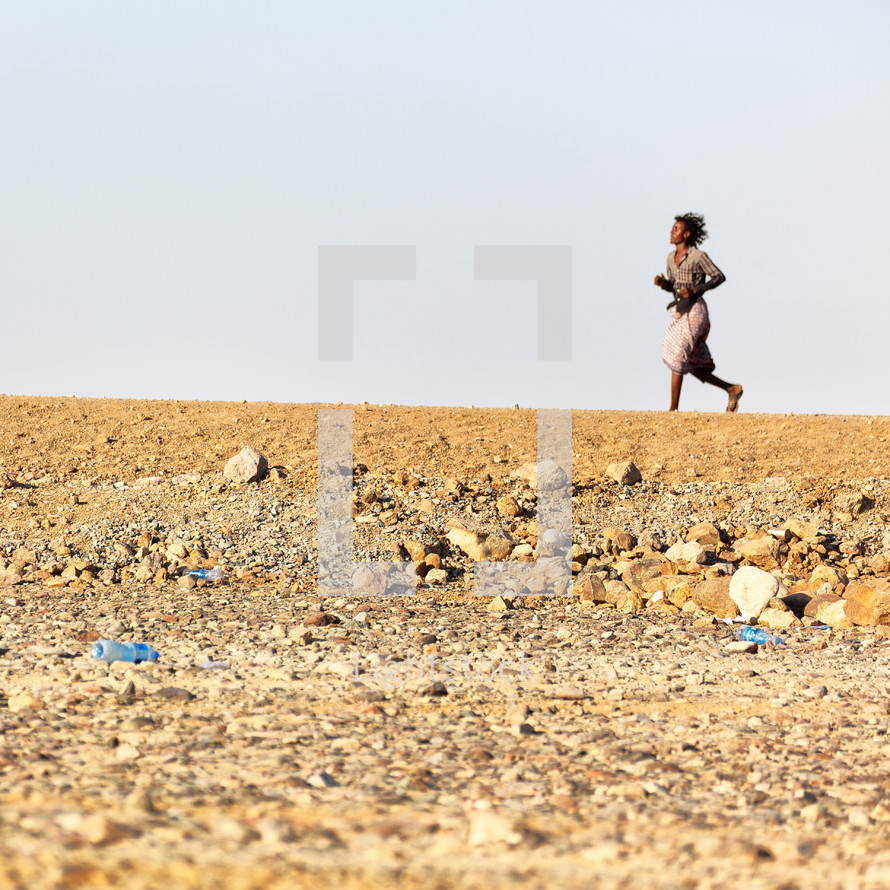 woman running across a desert 