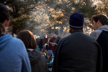 people reading a Bible and listening to scripture at a campsite 