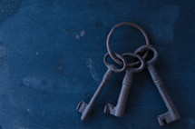 Old ring of keys against grimy background of stains and blemishes.