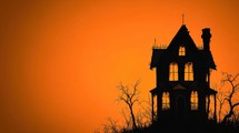 Spooky Haunted House Silhouette against an Orange Sunset, Halloween Concept