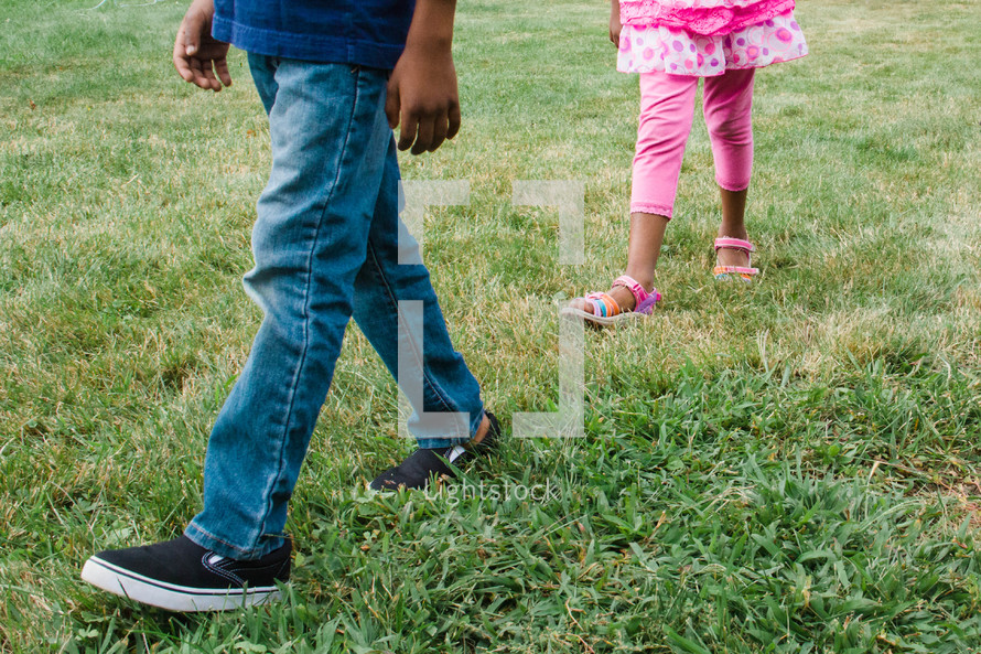 children's legs walking in grass 