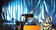 microphone and wooden stand over blurred blue blackground
