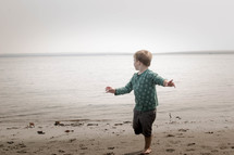 toddler running on a lake shore 