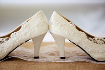 white high heeled shoes on burlap 