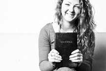 teen girl holding a Bible smiling