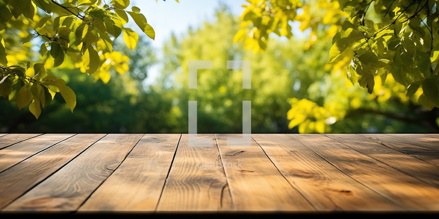 Empty wooden table for product placement in front of green nature background