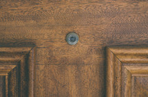 Peep hole in a wooden door.