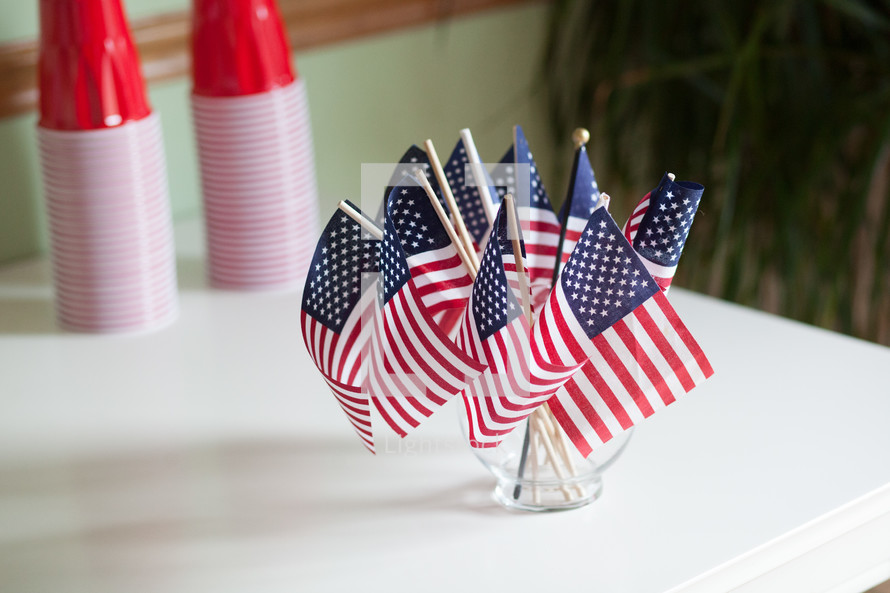 American flags in a vase and red cups 