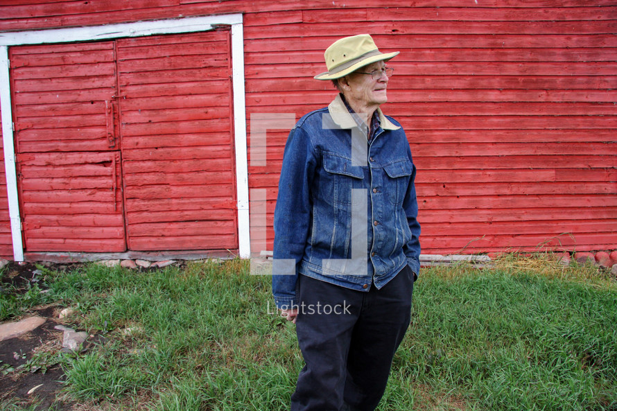 grandfather in front of a red barn 