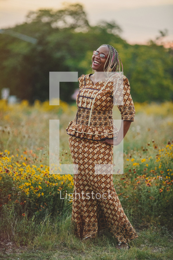 portrait of an African-American woman smiling standing in a field of wildflowers 