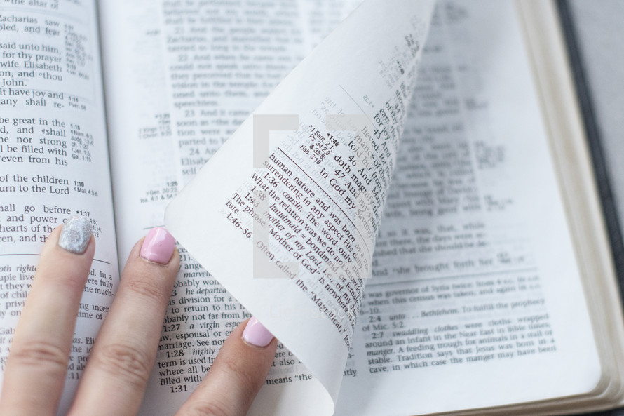 hand turning pages of a Bible 