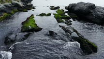 water flowing over rocks along a shore 