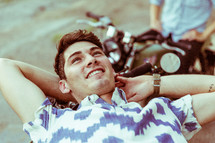 a man resting on a motorcycle 