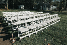 rows of white folding chairs for a wedding 