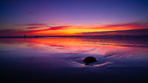 Ocean at sunset with purple sky.